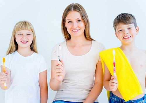 Mom and kids with toothbrushes image